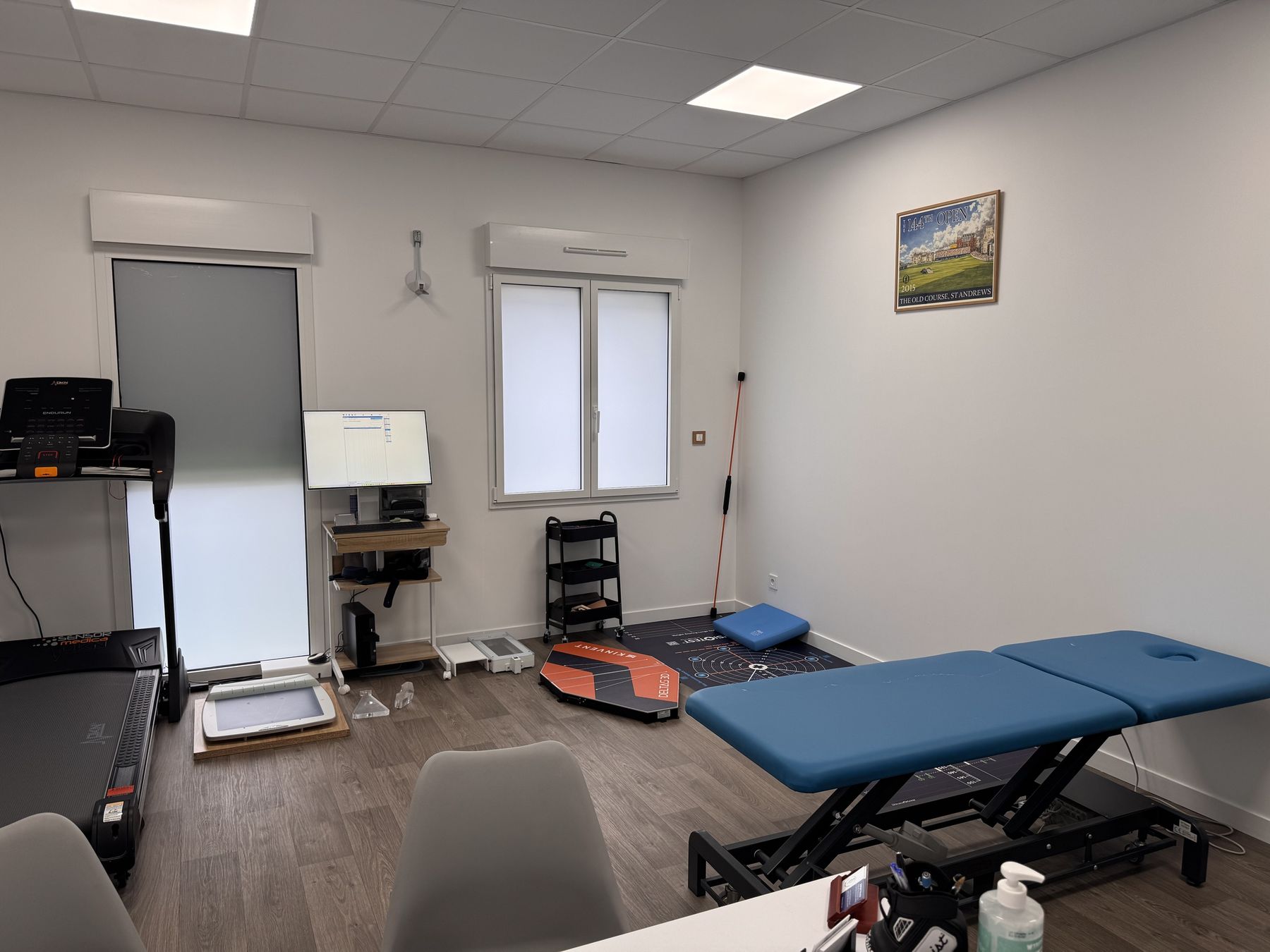 Salle de bilan du cabinet : tapis de course, plateformes de mesure et table d'examen